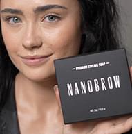 Fyrirsæta með dökkt hár heldur á Nanobrow stílsápuboxinu